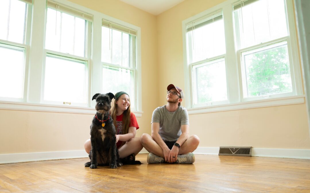 students in a bare house with their dog